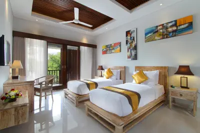 a bedroom with two beds and a desk at The Murdha Villa in Seminyak