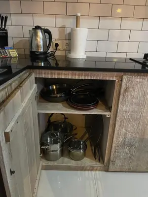 a kitchen cabinet with pots and pans in it at Pennylane Villa in Seminyak
