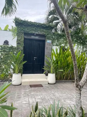 a black door with plants in front of a building at Pennylane Villa in Seminyak
