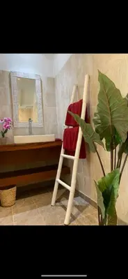 a bathroom with a red towel on a chair in front of a sink at Villa Giulia in Seminyak