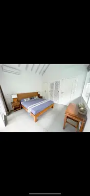a bedroom with a bed and a wooden table at Villa Giulia in Seminyak