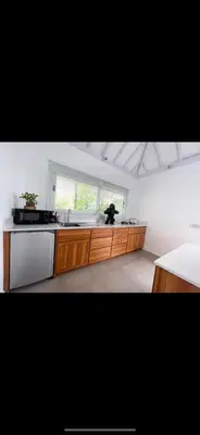 a kitchen with wooden cabinets and a sink and a window at Villa Giulia in Seminyak