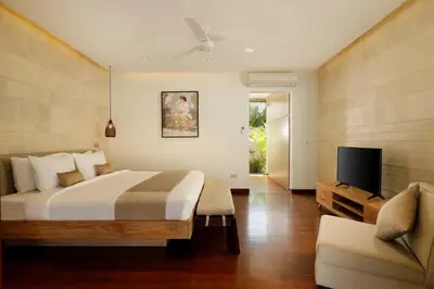 a bedroom with a bed and a tv and a couch at Villa Tenang by Nakula in Canggu