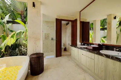 a bathroom with a tub and a sink and a mirror at Villa Tenang by Nakula in Canggu