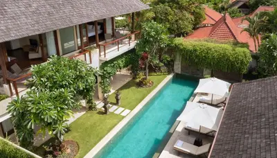 an aerial view of a swimming pool with umbrellas at Villa Tenang by Nakula in Canggu
