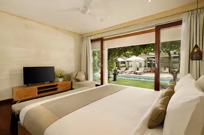 a bedroom with a large bed and a large window at Villa Tenang by Nakula in Canggu