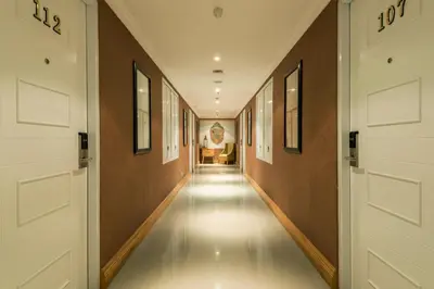 a hallway with two doors and a person in the background at Yan's House Hotel in Kuta