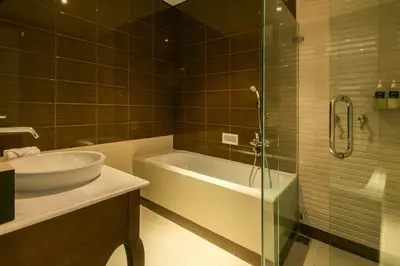 a bathroom with a tub and a sink and a shower at Yan's House Hotel in Kuta