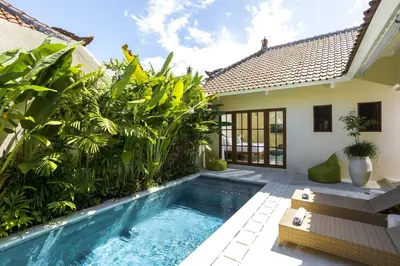 a pool in the backyard of a house with plants at Villa Mandala in Seminyak