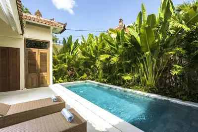 a swimming pool in front of a house at Villa Mandala in Seminyak