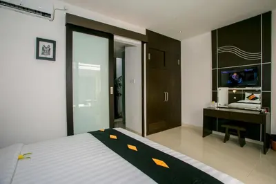 a bedroom with a bed and a desk and a tv at The Diana Suite in Kuta