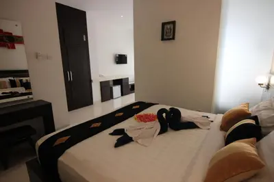 a bedroom with a bed with clothes on it at The Diana Suite in Kuta