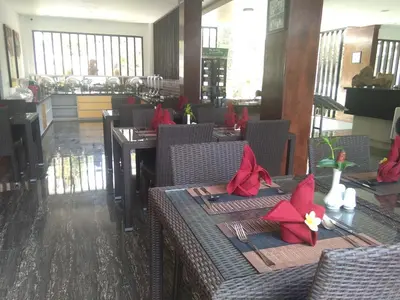 a dining room with tables and chairs with red napkins at The Diana Suite in Kuta