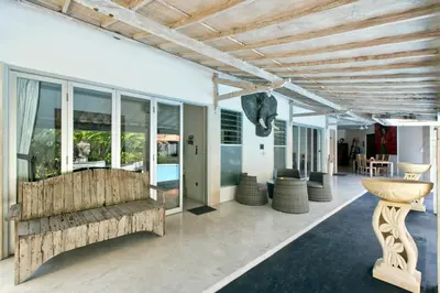 a living room with a couch and some windows at Grange Villa - Legian in Legian