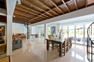 a dining room with a table and a couch at Grange Villa - Legian in Legian
