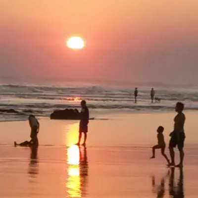 a group of people playing on the beach at sunset at Private Apartments at Jayakarta Resort in Legian