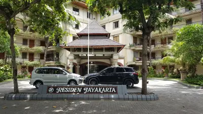 two vehicles parked in front of a building at Private Apartments at Jayakarta Resort in Legian