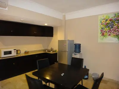 a kitchen with a table and a refrigerator at Private Apartments at Jayakarta Resort in Legian