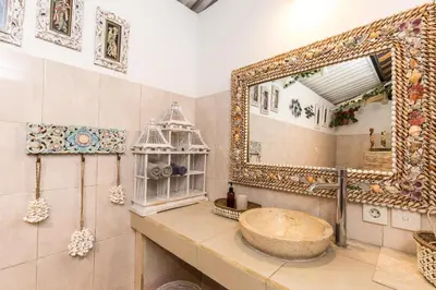 a bathroom with a large mirror and a sink at Villa Kamboja Younger in Seminyak
