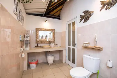 a bathroom with a toilet in a room at Villa Kamboja Younger in Seminyak