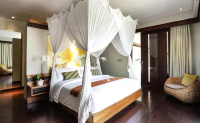 a bedroom with a canopy bed with white curtains at Sunset Paradise Villa Jimbaran 8008 in Jimbaran