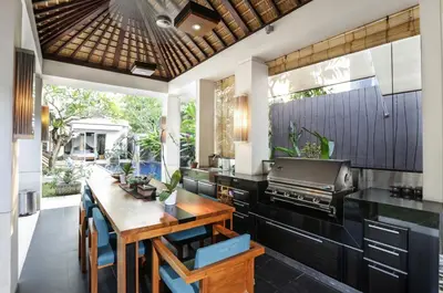 an open kitchen with a wooden table and a grill at Sunset Paradise Villa Jimbaran 8008 in Jimbaran