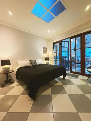 a bedroom with a bed with a black comforter at Villa Antiga 2 in Seminyak