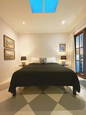 a bedroom with a large bed with two side tables at Villa Antiga 2 in Seminyak
