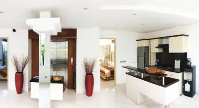 a kitchen with two red vases in a room at Flora Apartment Bali in Seminyak