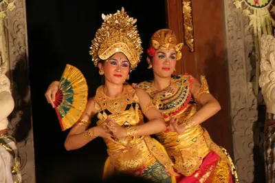 two women dressed in costumes holding an umbrella at Flora Apartment Bali in Seminyak