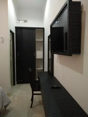 a living room with a television on a wall at Asta House in Kuta