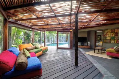a living room with colorful furniture on a wooden floor at Villa Sham in Seminyak