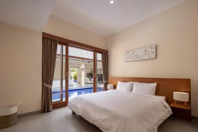 a bedroom with a bed and a large window at Villa Destino - Seminyak Bali in Seminyak