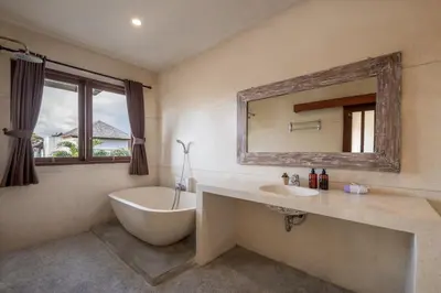 a bathroom with a tub and a sink and a mirror at Villa Destino - Seminyak Bali in Seminyak