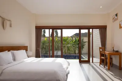 a bedroom with a large bed and a balcony at Villa Destino - Seminyak Bali in Seminyak