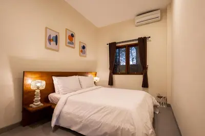 a bedroom with a white bed and a window at Villa Destino - Seminyak Bali in Seminyak
