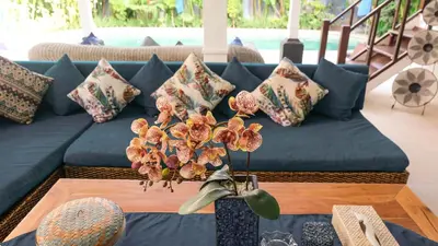 a blue couch with pillows on a table at Villa Alam Biru Gardenia in Seminyak