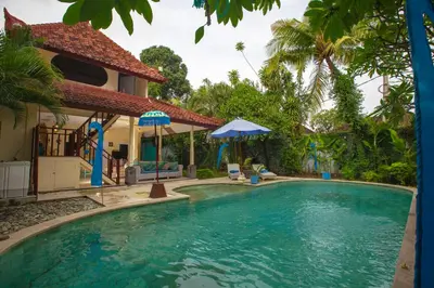 a swimming pool in front of a villa at Villa Alam Biru Gardenia in Seminyak