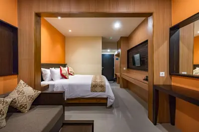 a hotel room with a bed and a tv at AB Hotel Kuta in Kuta