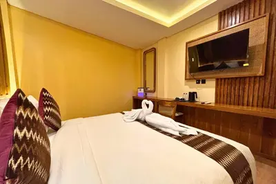 a hotel room with a bed and a tv at AB Hotel Kuta in Kuta