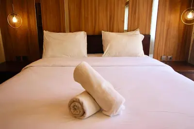 a hotel room with a towel on a bed at AB Hotel Kuta in Kuta