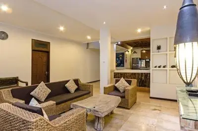 a living room with a couch and chairs and a table at Villa Tiah in Kuta