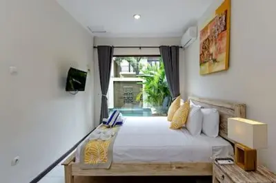 a bedroom with a large bed and a window at Villa Tiah in Kuta
