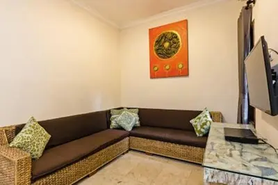 a living room with a couch and a television at Villa Tiah in Kuta
