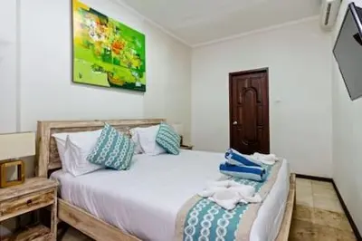 a bedroom with two beds with towels on them at Villa Tiah in Kuta