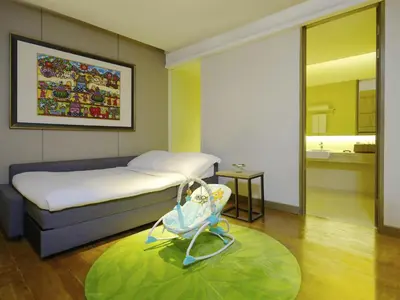 a hotel room with a bed and a baby swing at Mövenpick Resort & Spa Jimbaran Bali in Jimbaran