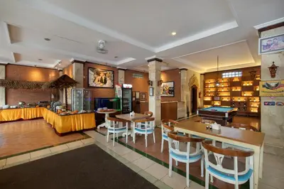 a restaurant with tables and chairs and a pool table at Legian Village Beach Resort - CHSE Certified in Legian