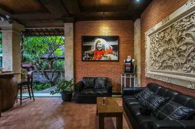 a living room with black leather furniture and a brick wall at Legian Village Beach Resort - CHSE Certified in Legian