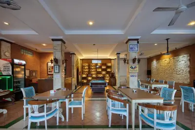a dining room with tables and chairs and a library at Legian Village Beach Resort - CHSE Certified in Legian