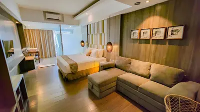 a hotel room with a couch and a bed at The Crystal Luxury Bay Resort Nusa Dua in Nusa Dua